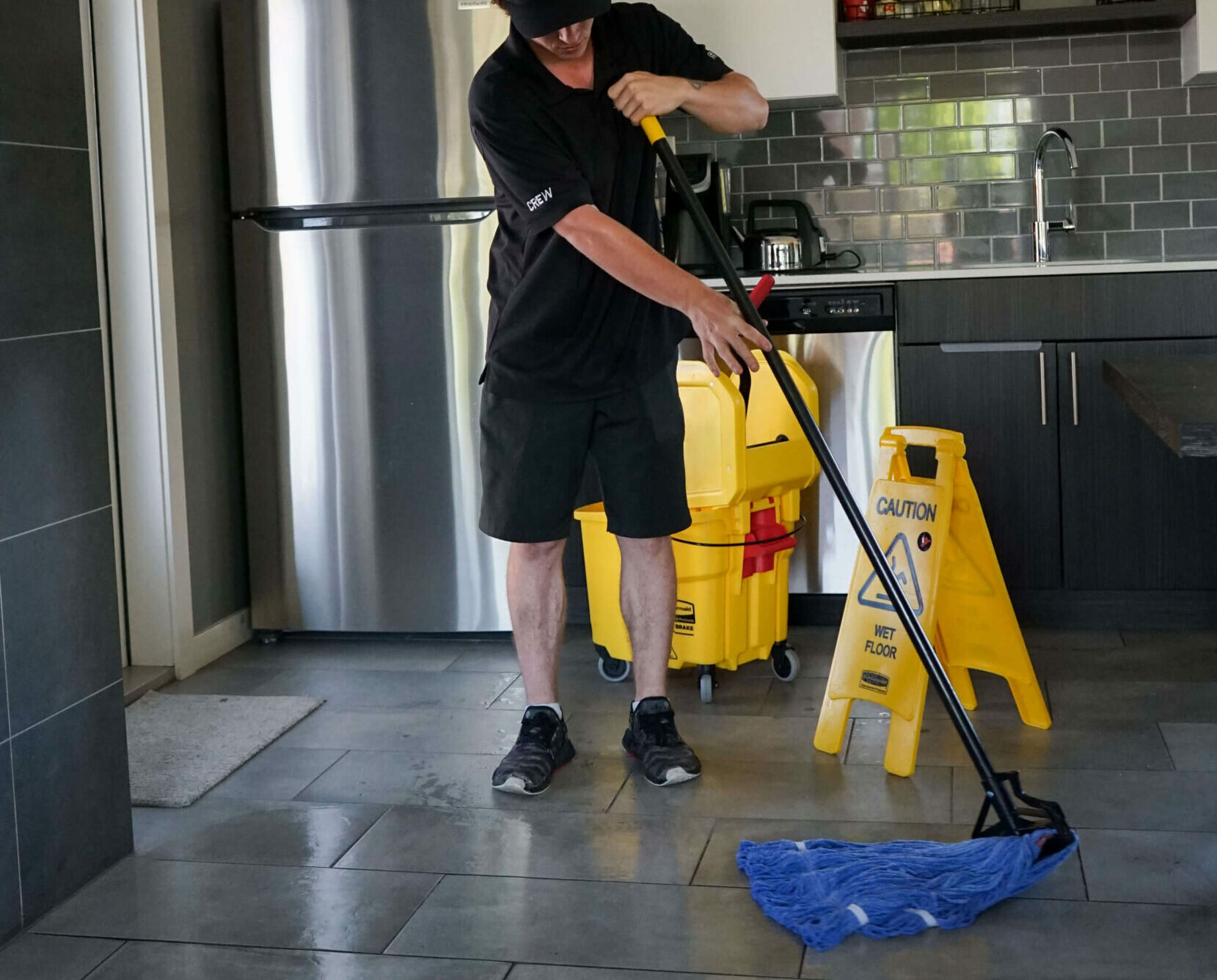 Good Sorts cleaning crew member mopping floor