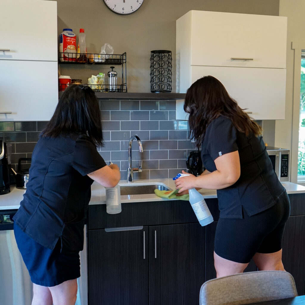 Good Sorts cleaning crew members cleaning office kitchen.