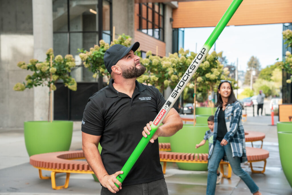 Good Sorts crew cleaning commercial windows holding green water fed pole