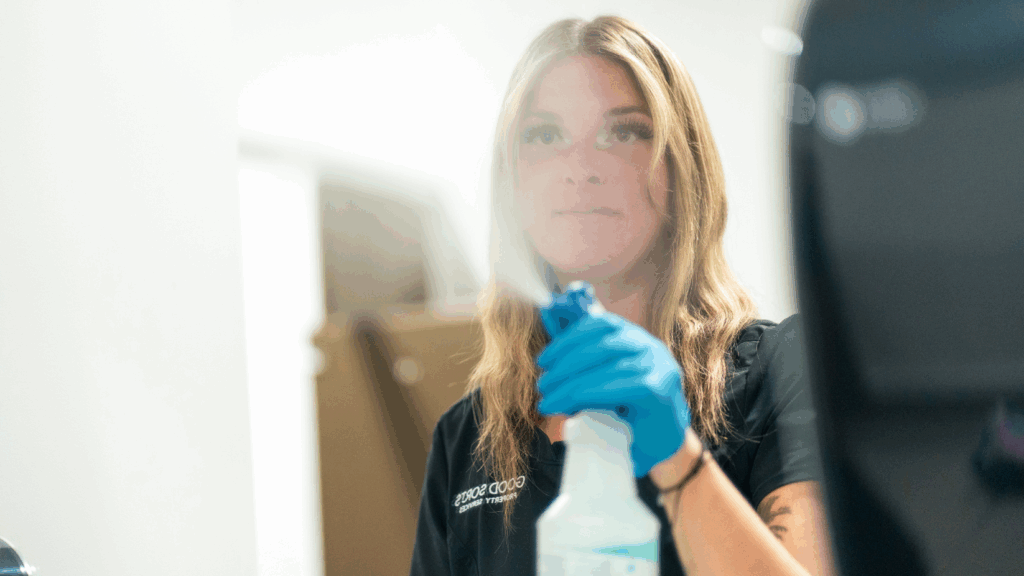 Good Sorts Cleaning Specialist spraying bathroom mirror