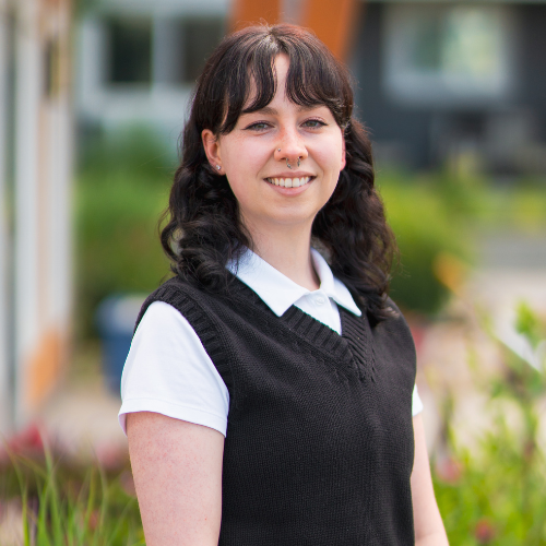 Alex Nagy, Operations Coordinator at Good Sorts Property Services, smiling with hands clasped in nature